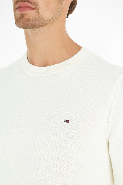 Ecru crewneck sweater by Tommy Hilfiger with ribbed neckline and small flag logo on chest, close-up front view