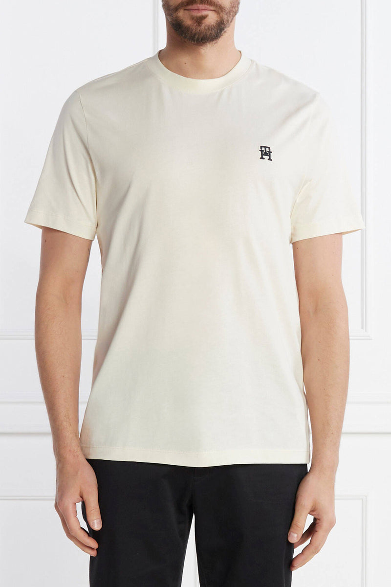 Ecru short-sleeve t-shirt by PH with small black logo on chest, worn with black pants, front view