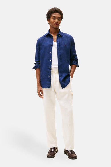 Donkerblauwe blouse met lange mouwen van TOMMY HILFIGER, open gedragen over een wit T-shirt, met een beige broek.