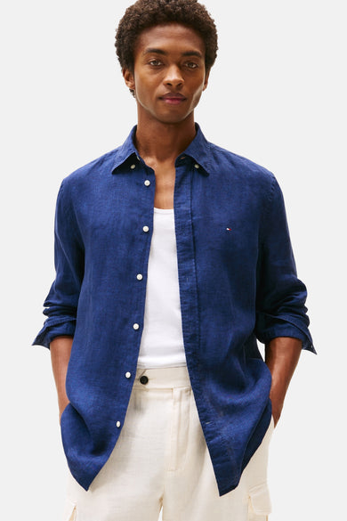 Donkerblauwe blouse met lange mouwen van TOMMY HILFIGER, open gedragen over een hemdje, met een crèmekleurige broek.