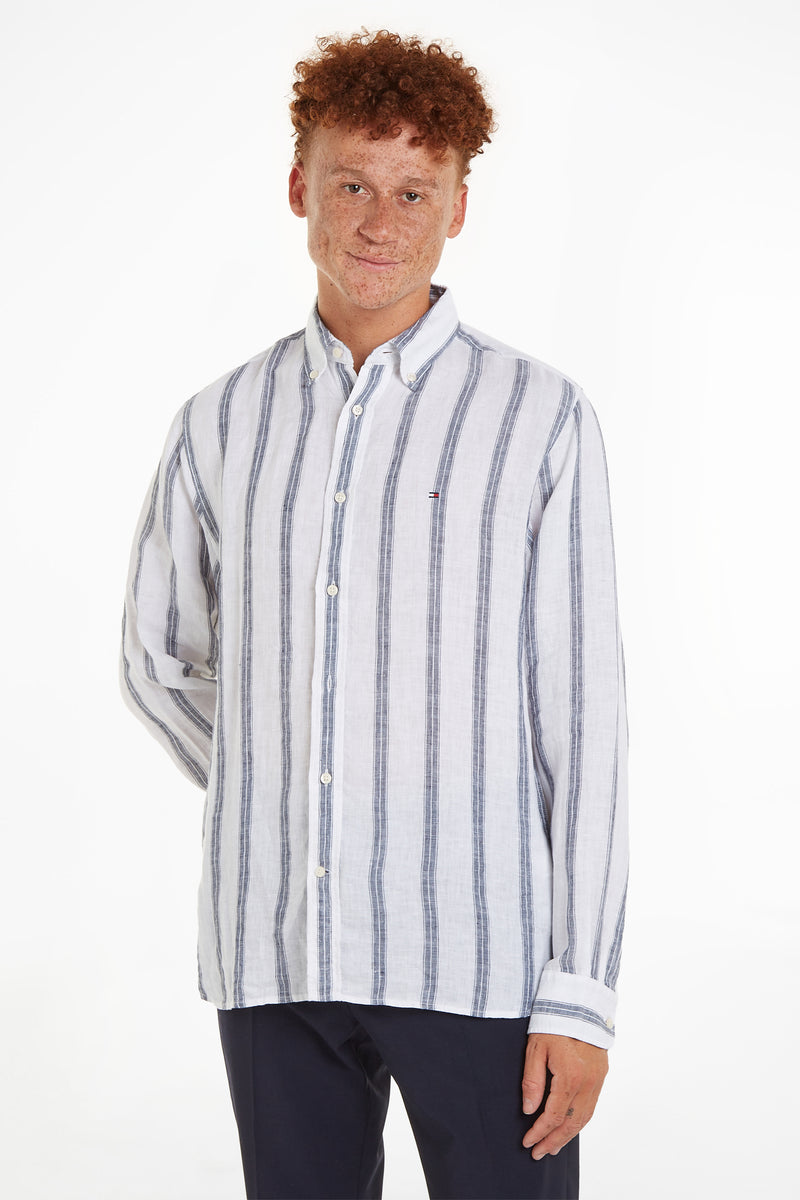Chemise à manches longues bleue et blanche à rayures, de TOMMY HILFIGER, portée par un homme aux cheveux roux.