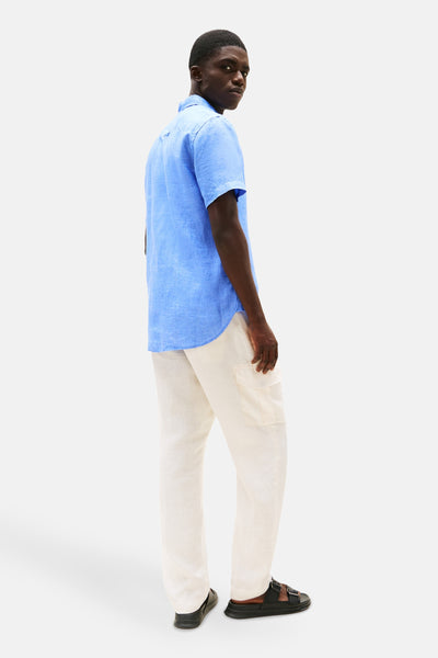 Blauw overhemd met korte mouwen van TOMMY HILFIGER, gedragen met een beige linnen cargobroek en zwarte sandalen.