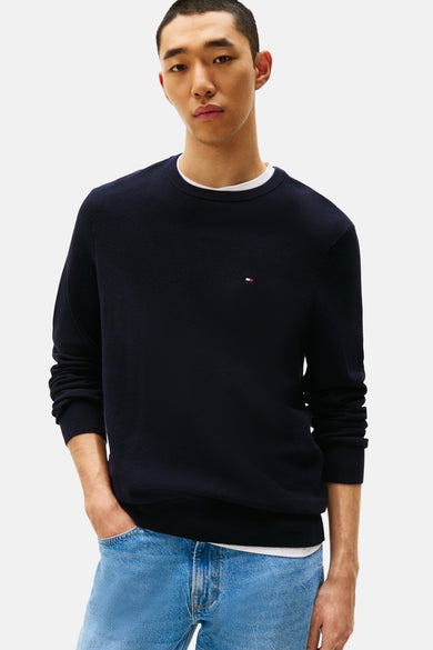 Pull à col rond bleu marine de TOMMY HILFIGER, motif texturé discret, porté avec un jean clair.