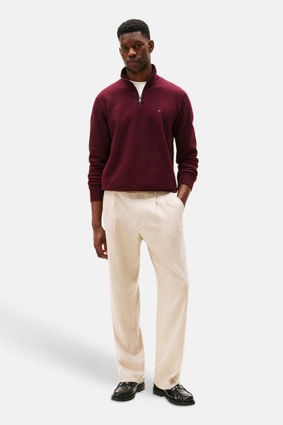 Bordeaux trui met opstaande kraag van TOMMY HILFIGER, gedragen met een beige broek en zwarte loafers.