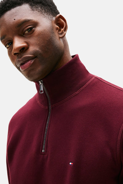 Bordeauxrode sweater met opstaande kraag van Tommy Hilfiger met zilveren ritssluiting en discreet logo.