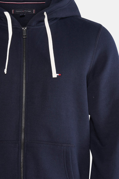 Marineblauwe Tommy Hilfiger zip-hoodie met witte trekkoorden en discreet logo.