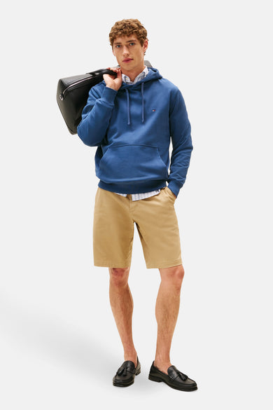 Blauwe hoodie van TOMMY HILFIGER, gedragen met een overhemd en een zwarte leren tas.