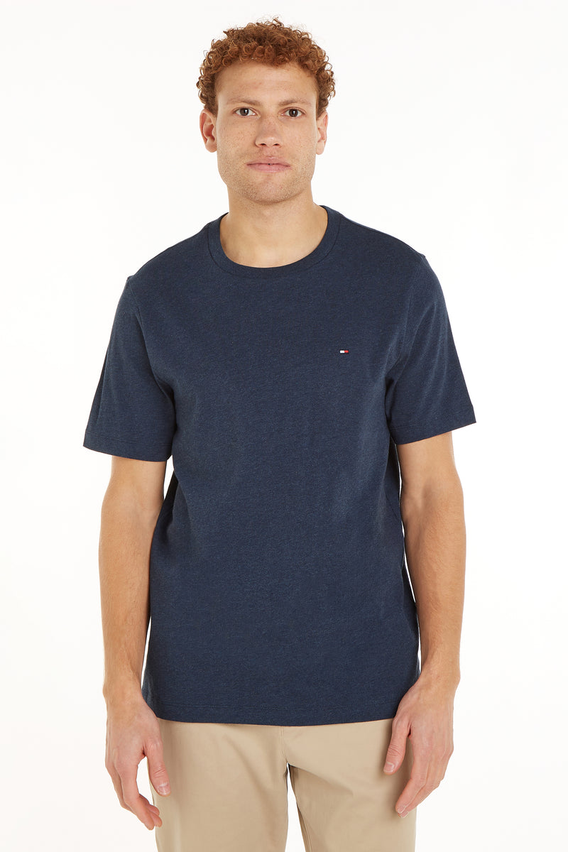 Blauw T-shirt met korte mouwen van Tommy Hilfiger, op een man die een beige broek draagt, vooraanzicht.