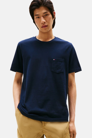 Marineblauwe T-shirt met korte mouwen van Tommy Hilfiger met borstzak, gedragen met een kaki broek.