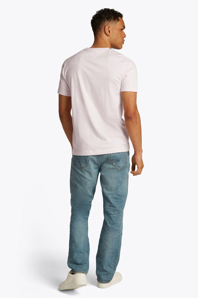 Roze T-shirt met korte mouwen van TOMMY HILFIGER, gedragen met een blauwe spijkerbroek en witte sneakers, achtergezicht.