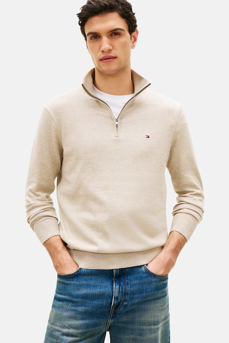 Beige coltrui van TOMMY HILFIGER, gedragen met een wit T-shirt en een lichtblauwe spijkerbroek, met bruine schoenen.