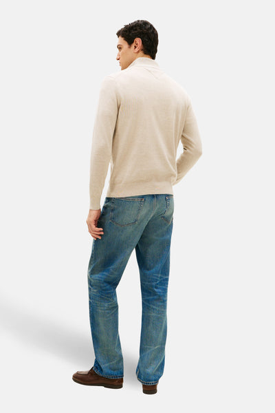 Beige coltrui van TOMMY HILFIGER, gedragen met een blauwe jeans en bruine bootschoenen, achterzijde.