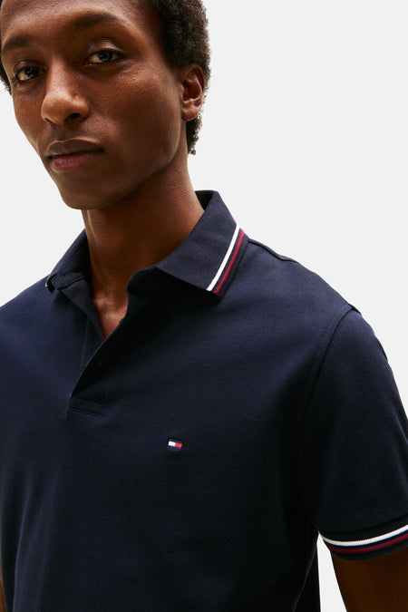 Polo bleu marine en maille piquée de Tommy Hilfiger, avec rayures contrastantes au col et aux manches.
