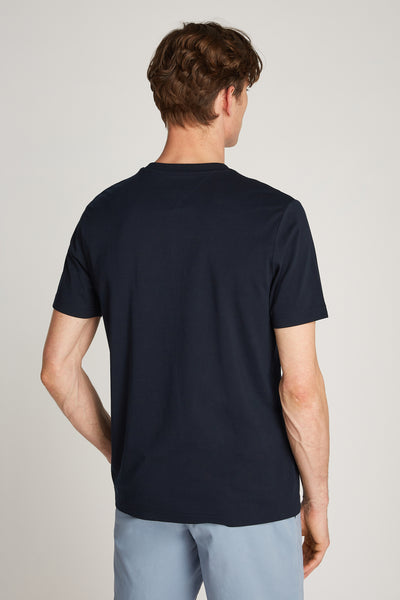 T-shirt à manches courtes bleu de TOMMY HILFIGER, vu de dos, porté avec un pantalon bleu clair.