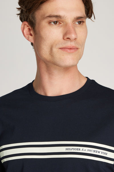 T-shirt bleu à manches courtes de Tommy Hilfiger avec rayures blanches horizontales sur le devant.