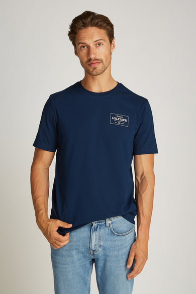 T-shirt à manches courtes bleu par TOMMY HILFIGER, porté avec un jean en denim clair.
