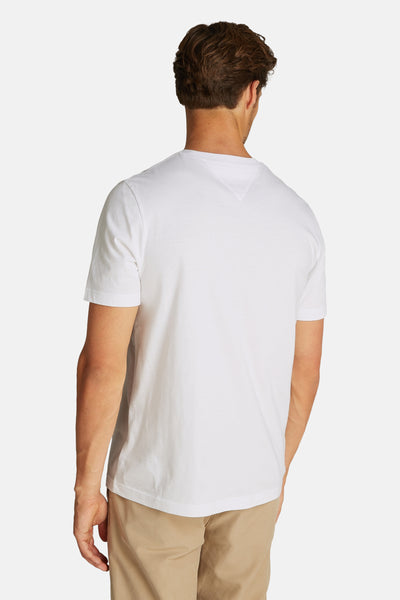 T-shirt blanc à manches courtes de Tommy Hilfiger, vu de dos, porté avec un pantalon beige.