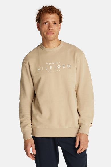 Sweat-shirt beige de TOMMY HILFIGER avec logo imprimé sur le devant et manches longues.