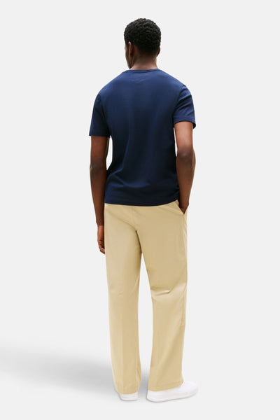 Blauw T-shirt met korte mouwen van TOMMY HILFIGER, gedragen met een beige broek en witte sneakers, achtergezicht.