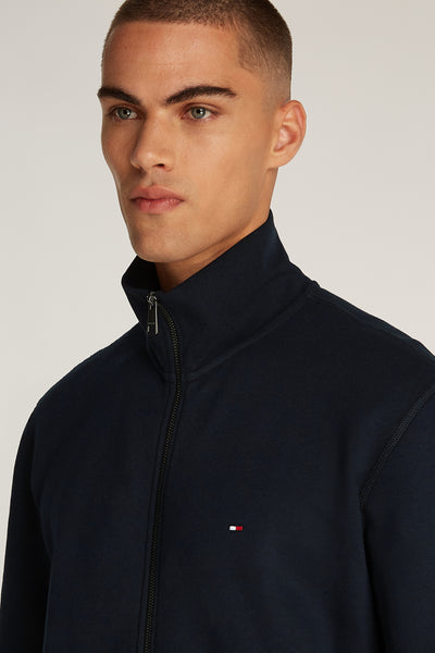 Donkerblauwe Tommy Hilfiger hoodie met ritssluiting en logo op de borst.