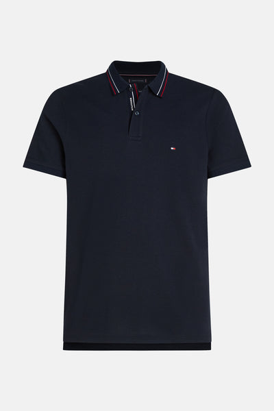 Polo à manches courtes bleu de TOMMY HILFIGER, avec col rayé rouge et blanc et logo discret.