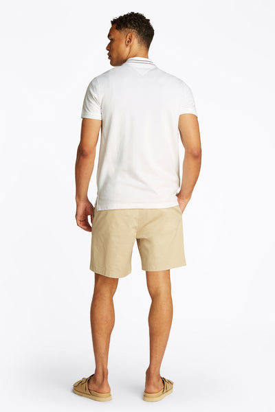 Wit poloshirt met korte mouwen van Tommy Hilfiger, gedragen met een beige korte broek en sandalen. Achterzicht.