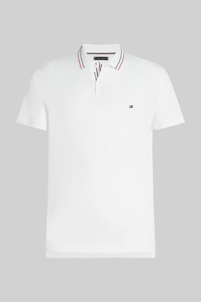 Polo à manches courtes blanc de TOMMY HILFIGER, avec rayures rouges et bleues marine au col et petit logo sur la poitrine.