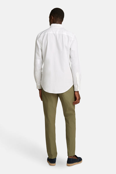 Chemise à manches longues blanche de TOMMY HILFIGER, portée avec un pantalon vert olive et des espadrilles bleu marine, vue de dos.