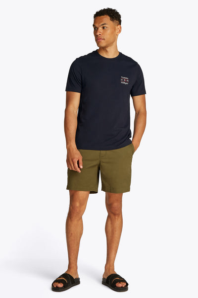 Marineblauwe T-shirt met korte mouwen van Tommy Hilfiger met discreet logo op de borst, gedragen met een olijfgroene korte broek.