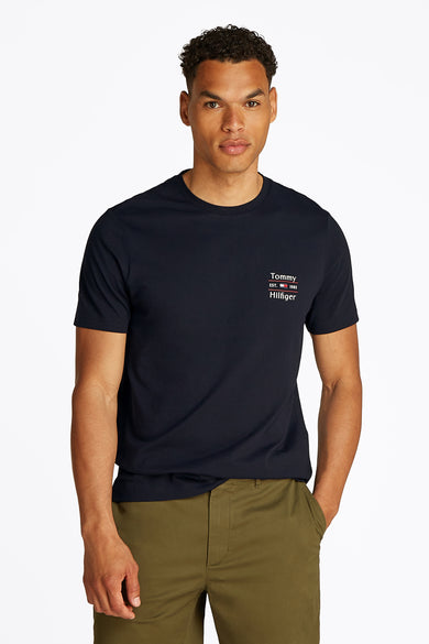 Marineblauw T-shirt met korte mouwen van Tommy Hilfiger met logo op de borst, gedragen met een kaki broek.