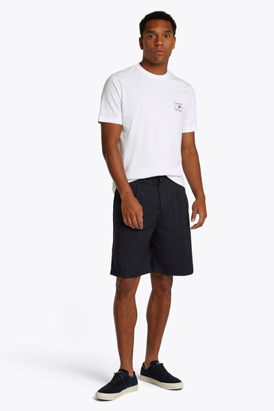 Wit T-shirt met korte mouwen van TOMMY HILFIGER, gedragen met een marineblauwe korte broek en sneakers.
