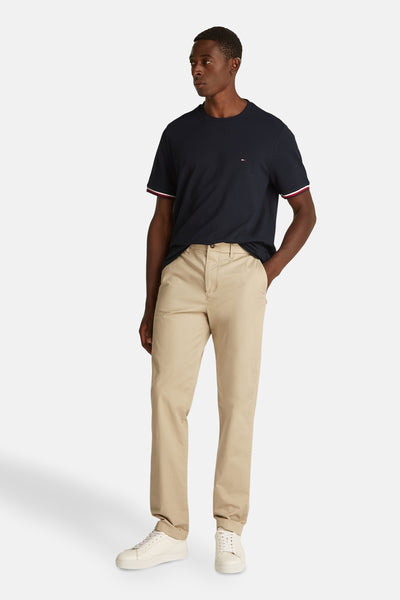 Donkerblauwe T-shirt met korte mouwen van TOMMY HILFIGER, met contrasterende bies op de mouwen, gedragen met een beige broek.