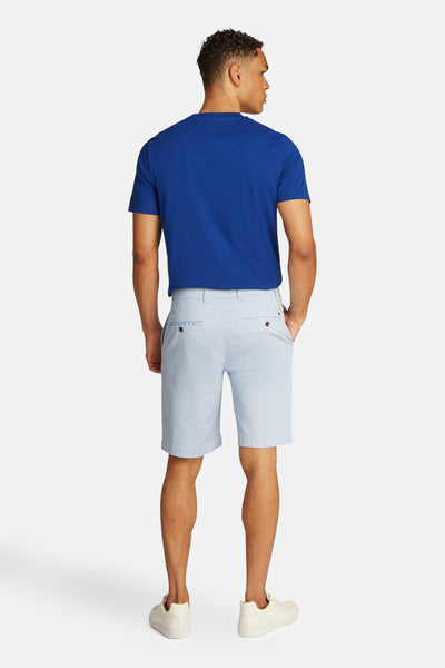 Lichtblauwe korte broek van Tommy Hilfiger, gedragen met een blauw T-shirt en witte schoenen, achtergezien.