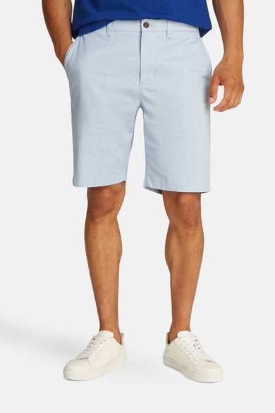 Lichtblauwe short van Tommy Hilfiger gedragen met een blauw T-shirt en witte sneakers.