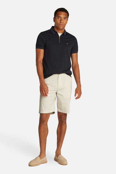 Ecru short van TOMMY HILFIGER, gedragen met een marineblauw poloshirt en beige espadrilles.