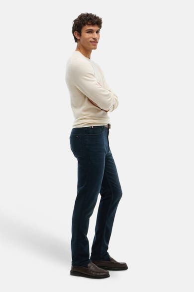 Blue black straight-fit denim jeans by DENTON, worn with cream sweater and brown loafers, side view