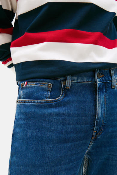 Jean slim bleu moyen de TOMMY HILFIGER, avec poche gousset et détails de couture contrastés.
