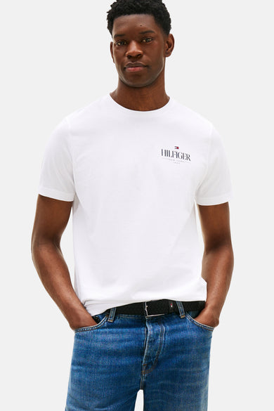 T-shirt blanc à manches courtes de TOMMY HILFIGER, porté avec un jean et une ceinture noirs.