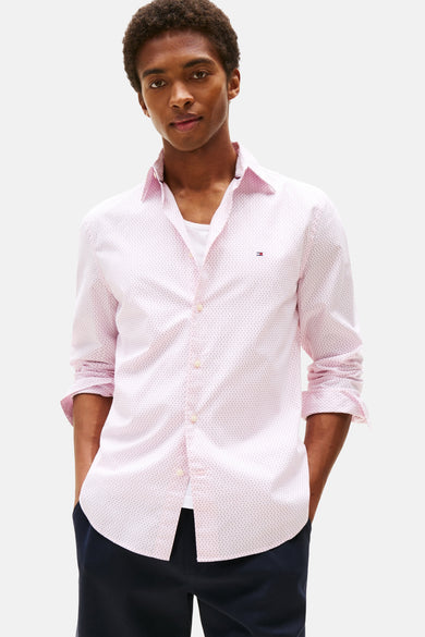 Roze overhemd met lange mouwen en stippenpatroon van TOMMY HILFIGER, gedragen met een marineblauwe korte broek en witte sneakers, van achteren gezien.