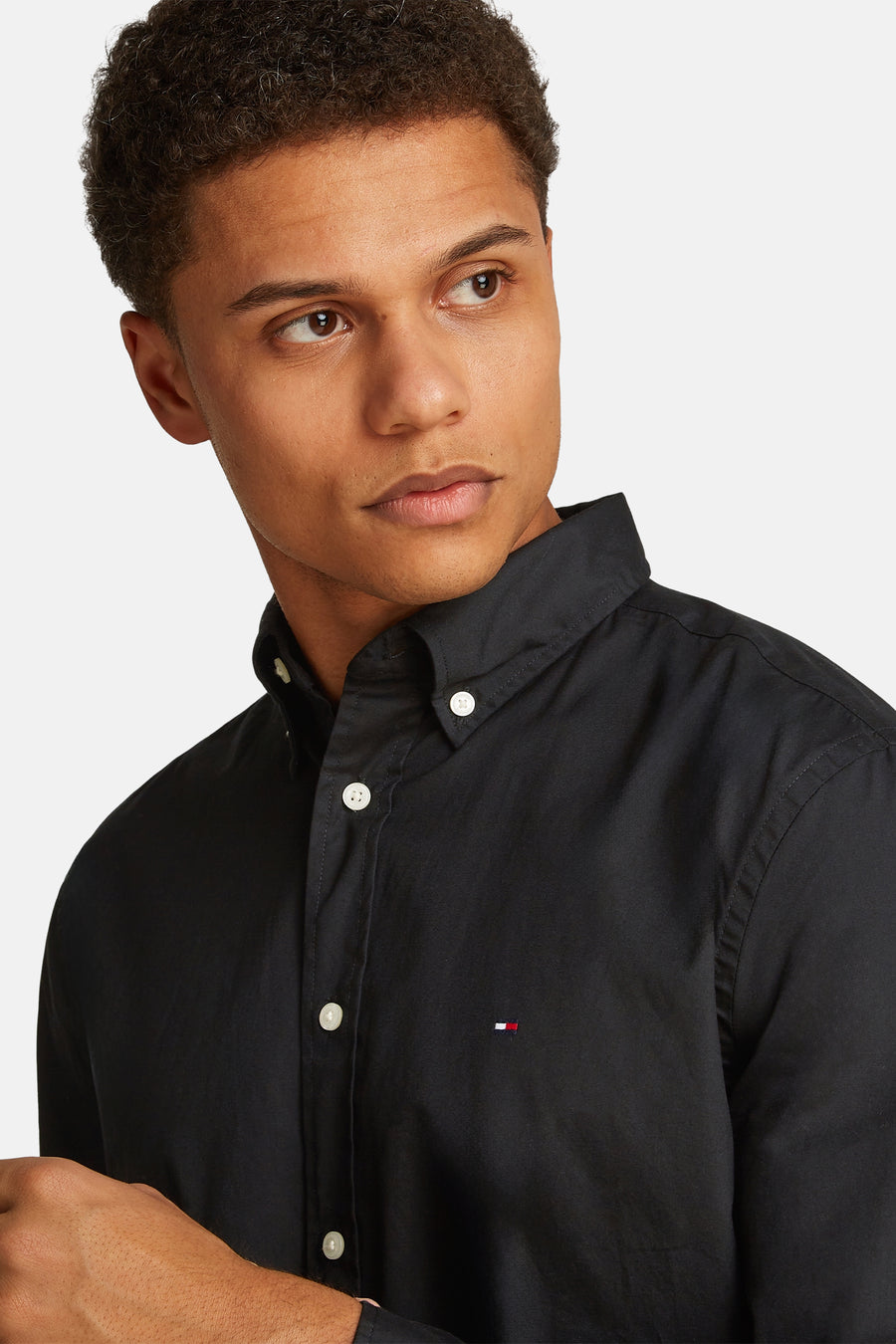 Chemise noire à manches longues de Tommy Hilfiger, avec boutons blancs et logo de la marque brodé.