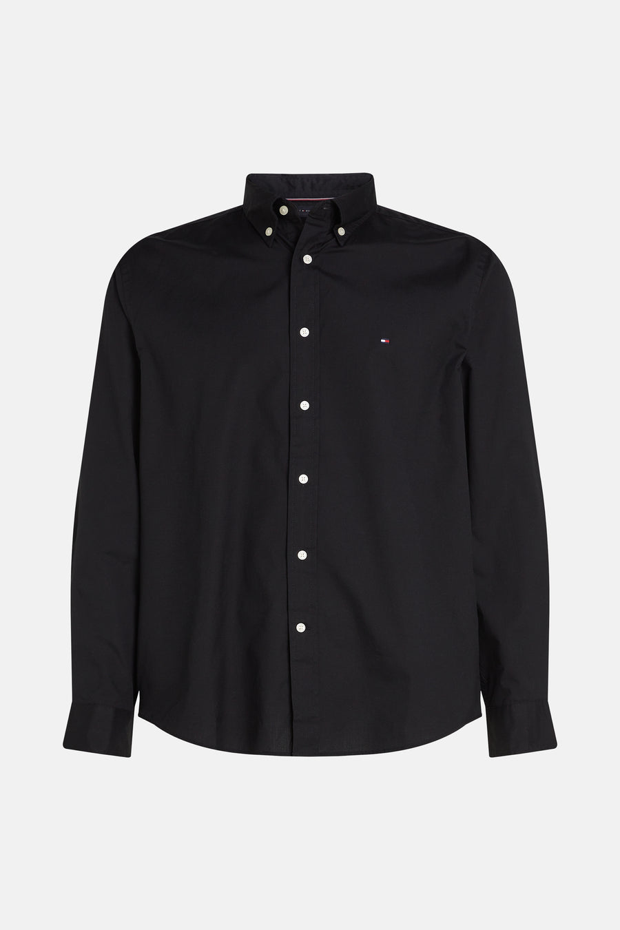 Chemise noire à manches longues de Tommy Hilfiger, boutonnée avec logo drapeau sur la poitrine.