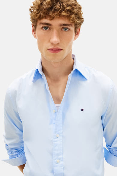 Chemise à manches longues bleu clair de Tommy Hilfiger, avec une patte de boutonnage et logo sur la poitrine.