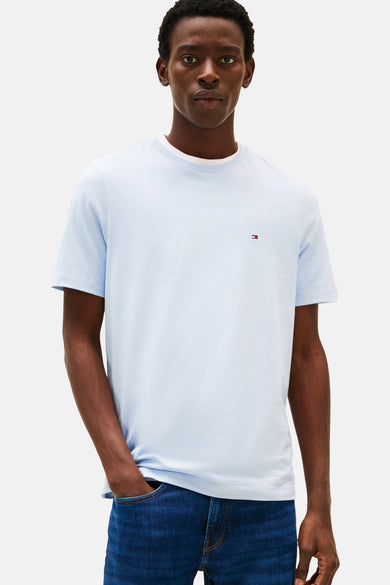 T-shirt bleu à manches courtes de TOMMY HILFIGER, avec un petit logo brodé sur la poitrine, porté avec un jean.