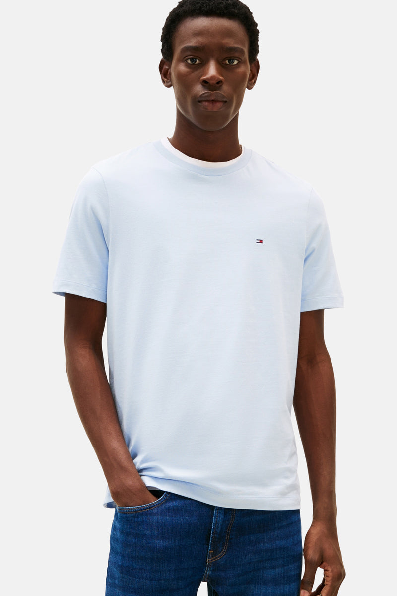 T-shirt bleu à manches courtes de TOMMY HILFIGER, avec un petit logo brodé sur la poitrine, porté avec un jean.