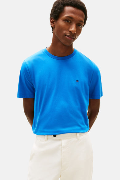 Blauw T-shirt met korte mouwen van TOMMY HILFIGER, gedragen met een witte broek en bruine bootschoenen.
