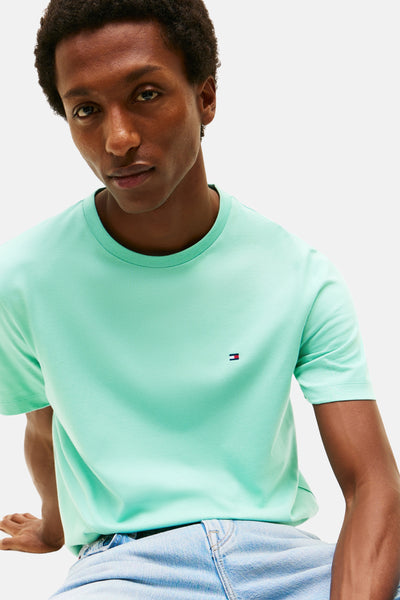 Blauw T-shirt met korte mouwen van TOMMY HILFIGER, gedragen met een verbleekte spijkerbroek.