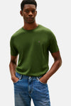 Groen T-shirt met korte mouwen van TOMMY HILFIGER, gedragen met een trui omgeknoopt en een blauwe jeans.