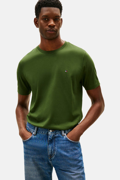 T-shirt vert à manches courtes de Tommy Hilfiger, porté avec un jean bleu.