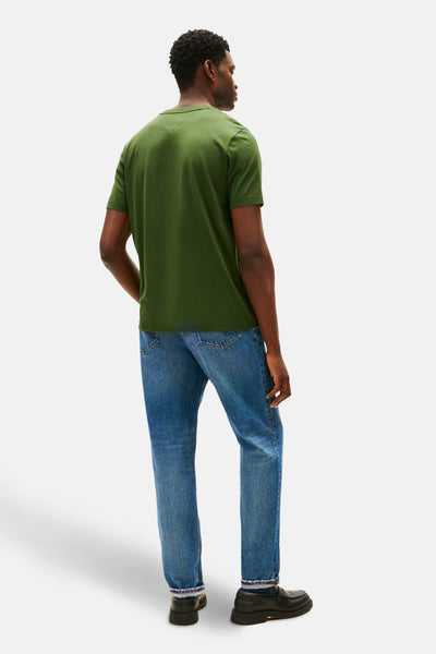 T-shirt vert à manches courtes de TOMMY HILFIGER, porté avec un jean bleu et des mocassins noirs, vue de dos.
