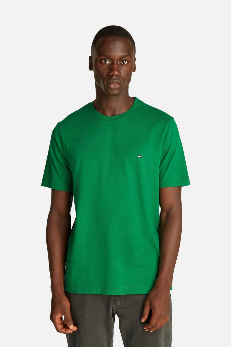 Groen T-shirt met korte mouwen van Tommy Hilfiger gedragen door een man, met een donkergrijze spijkerbroek eronder.